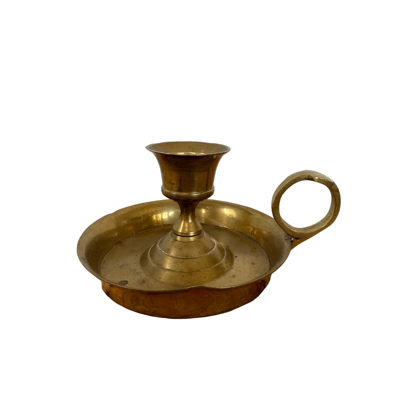 The Shoppe Maison Brass Candle Holder showcases a vintage design featuring a circular base with an integrated finger ring handle. It boasts a slightly elevated central support for a single candle and includes a discreet drip tray.