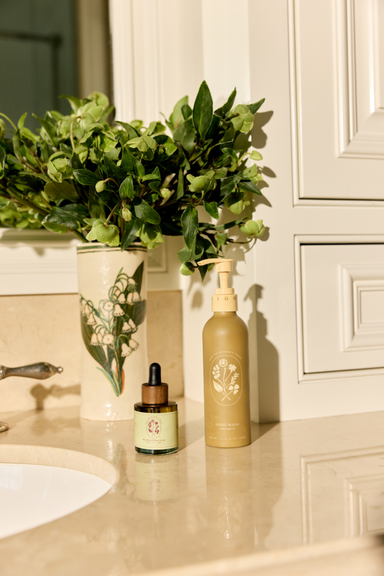 Close-up of a transparent, textured surface with an amber-colored liquid-filled tube and a ridged, golden spherical object partially embedded, creating an abstract composition.