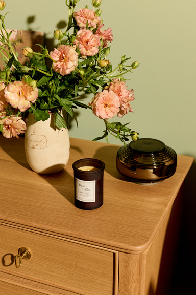 A close-up of a hand wearing a black ring, gracefully floating in gently rippling water. The skin is lightly tanned, and the water has a deep blue hue.