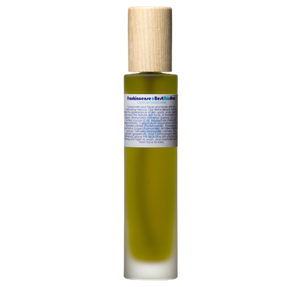 A sleek and minimalistic cylindrical bottle of green Best Skin Ever Cleanser - Frankincense by Living Libations, topped with a light wooden cap and labeled with detailed ingredients and uses, including its potential as an acne redness soothing cleanser exfoliator moisturizer, set against a black background.