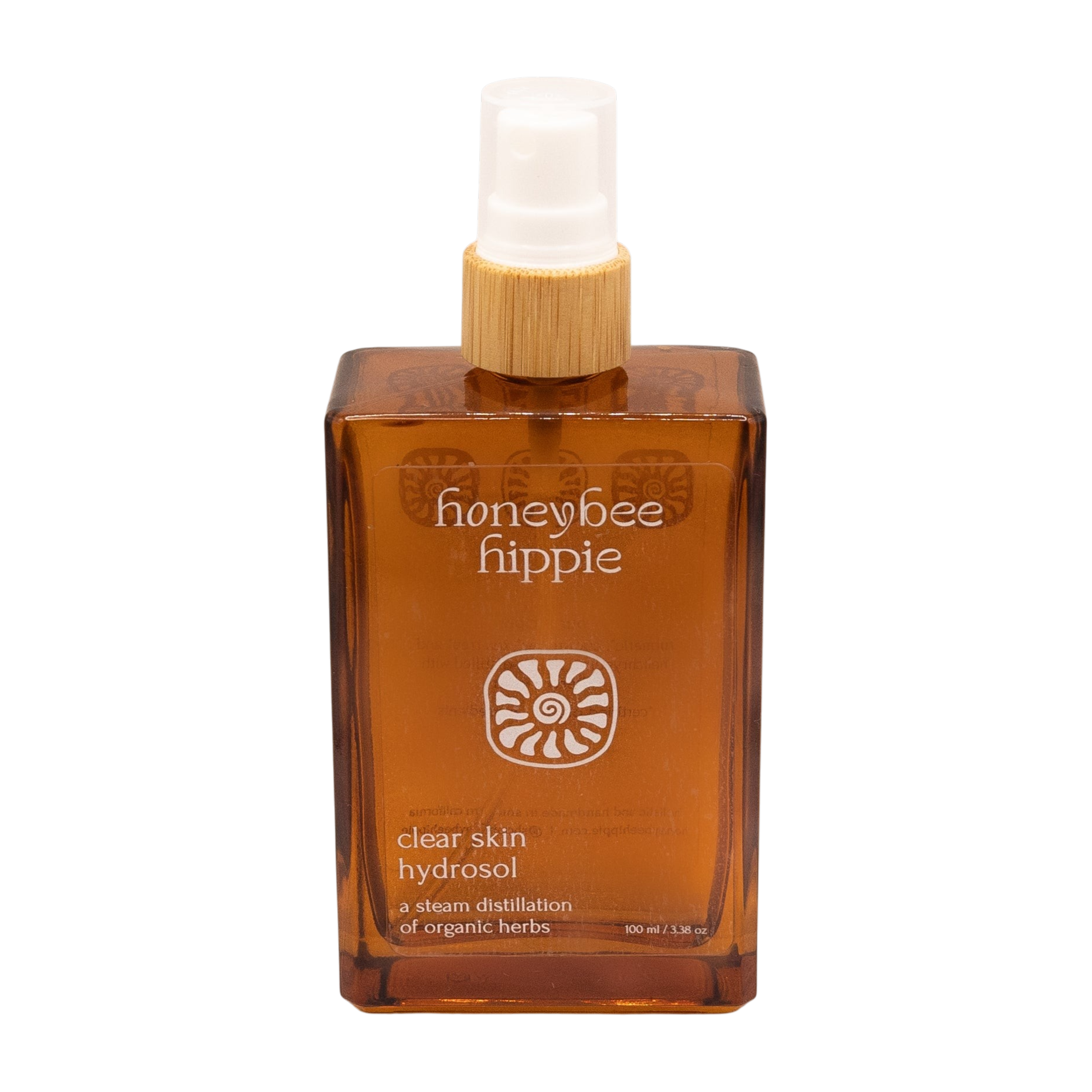 The Honeybee Hippie clear skin hydrosol comes in an amber spray bottle with a wooden cap and white nozzle, made from organic botanicals to complement green tea skincare routines.