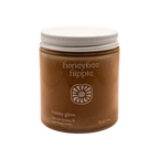 A minimalist brown jar with a white lid, labeled "Honeybee Hippie" and "honey glow," contains raw honey and sea moss wash—a gentle, soap-free facial cleanser—displayed against a plain white background.