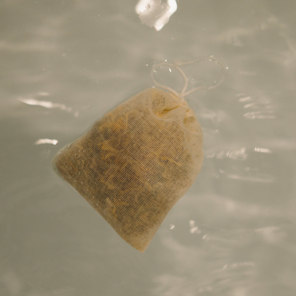 The Honeybee Hippie postpartum herbal sitz bath features a mesh pouch of organic herbs that floats on water, infusing your soak with calming botanicals for gentle, soothing self-care after childbirth.