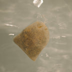 The Honeybee Hippie postpartum herbal sitz bath features a mesh pouch of organic herbs that floats on water, infusing your soak with calming botanicals for gentle, soothing self-care after childbirth.