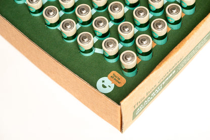 A cardboard box containing neatly arranged AA 40 Pack alkaline batteries from Better Battery Co. showcases a green smiley face and a label proclaiming, "World's Greenest Alkaline Battery." The packaging is recyclable and crafted from eco-friendly materials.
