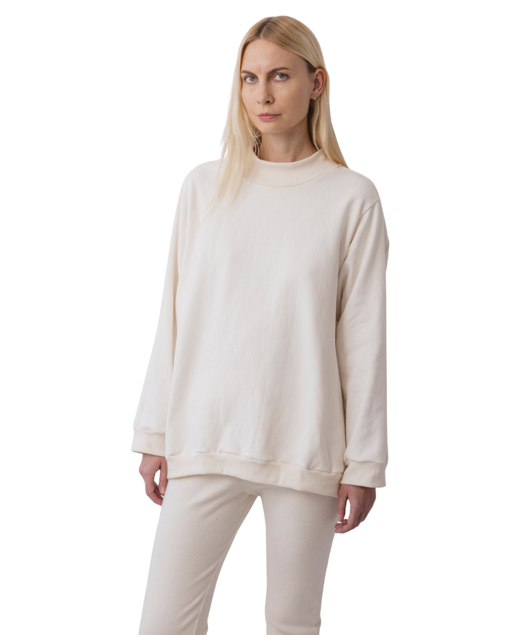 A person with long blonde hair wears Wol Hide's Big Sweatshirt in Natural, paired with matching pants, and stands against a plain white background.