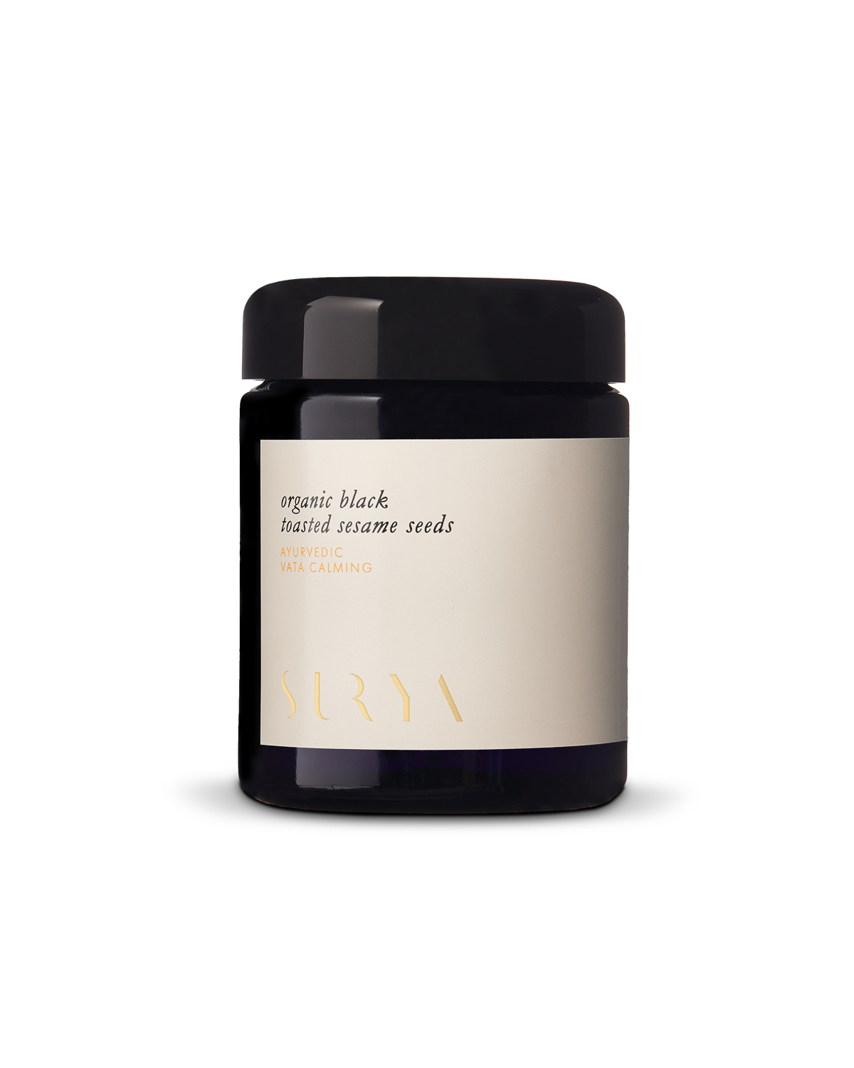 A dark glass jar with a black lid and cream label reads “Organic Black Sesame Seeds—rich in plant protein and antioxidants, ayurvedic, vata calming.” The Surya brand name is at the bottom.
