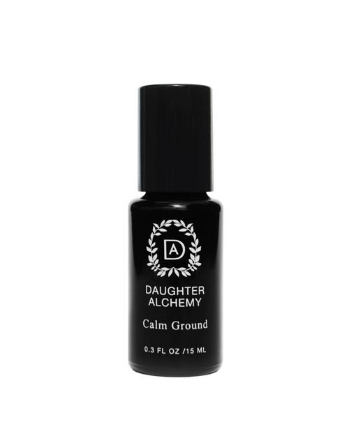 A 0.3 fl oz (15 ml) bottle of Daughter Alchemy’s Calm Ground® Botanical Calming Oil, with a black cap and a circular leaf design around "DA," crafted to help support anxiety relief.