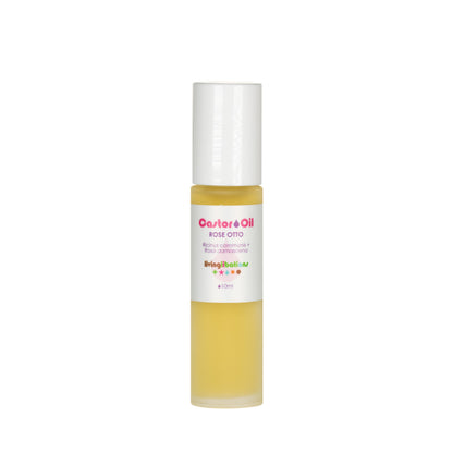 A small bottle of Castor Oil + Rose Otto by Living Libations is shown. The cylindrical bottle with a white cap contains yellow liquid rich in ricinoleic acids. The vibrant red and green text on the label makes it eye-catching and nourishing.