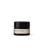 A small black jar with a beige label reading "Surya Cooling Lip Therapy" sits on a plain white background—an Ayurvedic lip balm by Surya designed for cooling lip therapy.