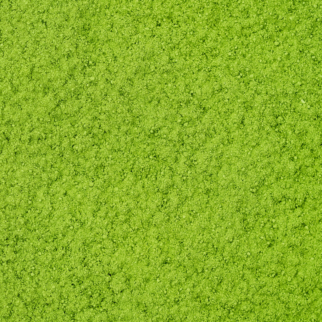 A close-up image of bright green Organic Stone Ground Ceremonial Matcha Gokoro from Chafinity Tea reveals a fine, slightly uneven, and grainy texture. The green color is consistent throughout, reminiscent of the uniformity seen in Japanese tea ceremonies or finely ground organic gyokuro green tea.