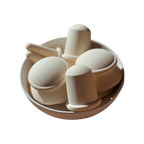 A round white bowl holds several off-white, dome-shaped and cylindrical silicone cupping cups with handles, embossed with "LENI." These are part of THE FACE & BODY CUPPING SET by LENI. The background is plain white.