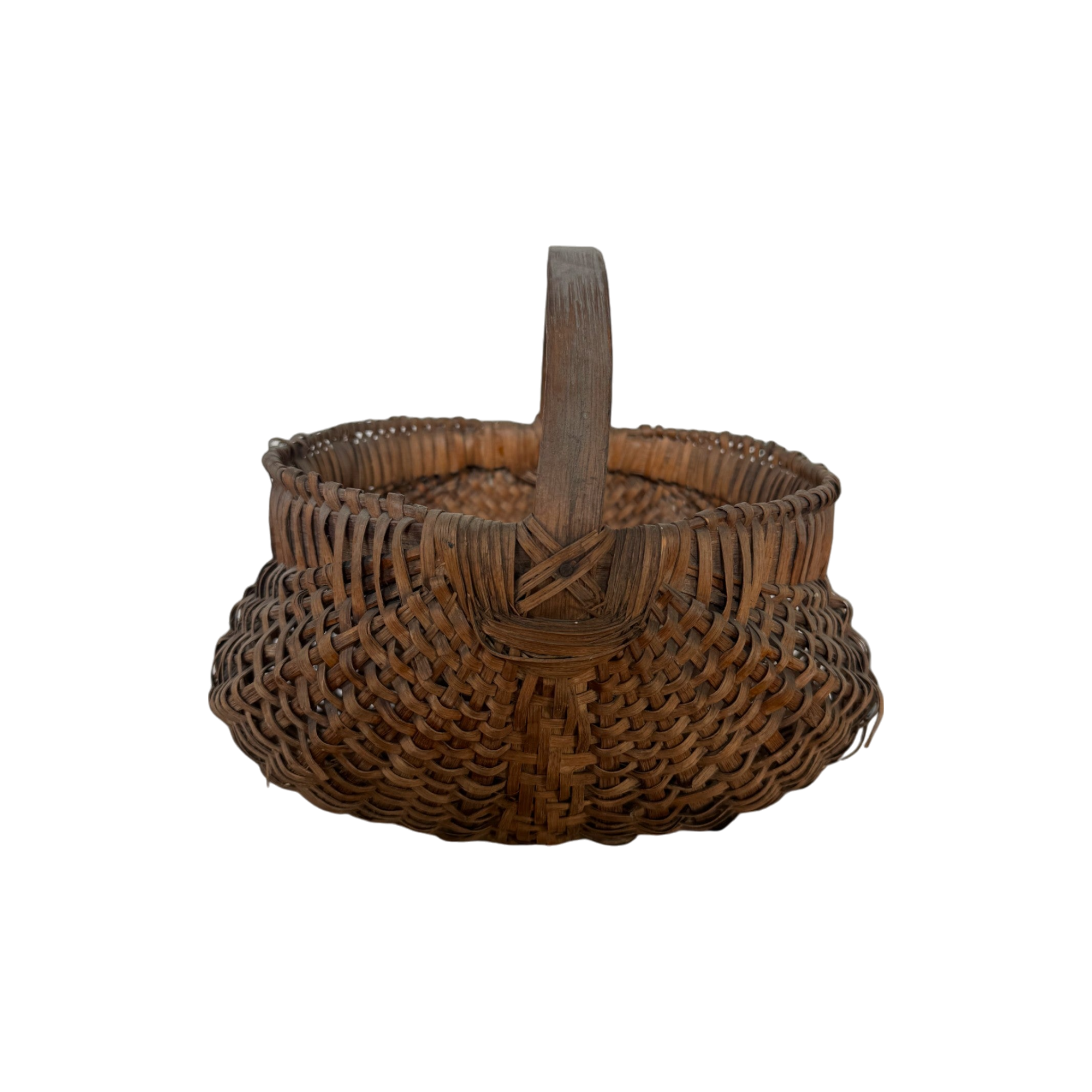 The Antique Gather Basket II by Shoppe Maison features a sturdy handle, rounded bottom, and decorative pattern. Reminiscent of antique buttocks baskets, this woven wicker basket appears empty and is displayed against a black background. The detailed and intricate weaving technique gives it a rustic, handcrafted feel perfect for decorative purposes.