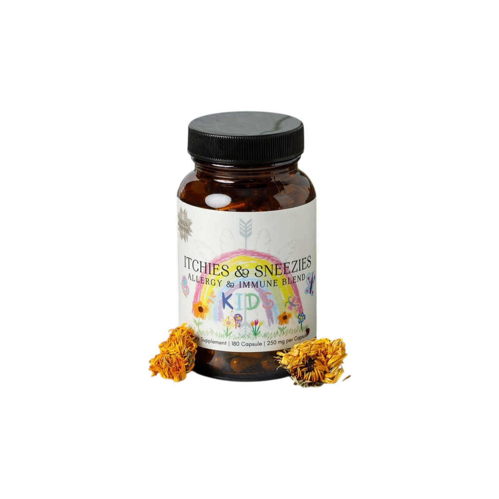 A brown bottle labeled "Wild Mamas Itchies & Sneezies - Allergy & Immune Blend" with yellow flowers on the label provides immune support for kids. Two dried yellow flowers are placed beside the bottle on a white background.