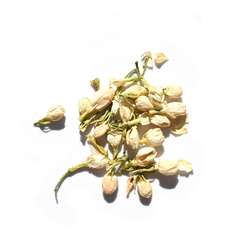 A small pile of dried jasmine flower buds with green stems on a white background—ideal for infusing Moon Mind® Botanical Intuition Oil by Daughter Alchemy, especially when blended with ylang ylang or organic jasmine oil.