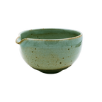 This small Katakuchi Matcha Tea Bowl from Chafinity Tea has a spout on one side and features a speckled ceramic texture. The surface showcases varying shades of green, with a darker base and a slightly uneven, handcrafted appearance. It's perfect for experiencing Japanese hospitality with Chafinity Tea.