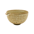 The Katakuchi Matcha Tea Bowl by Chafinity Tea is a beige ceramic piece featuring a small spout on one side, reminiscent of traditional Japanese bowl designs. Its speckled texture and slightly darker rim and interior pattern lend it a rustic charm. Set against a black background, this bowl embodies the essence of Japanese hospitality.