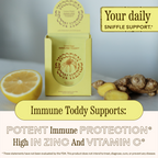 A box of WOODEN SPOON HERBS Lemon-Ginger Immune Toddy sits on a surface beside lemon and ginger. Text highlights immune support with elderberry, high vitamin C, and daily sniffle support. FDA disclaimer is shown.