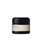 A black jar with a beige label reads "Balancing Collagen Cream" and "Surya." This minimalist natural face cream emphasizes Ayurvedic skincare, shown against a plain white background.