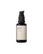 A dark glass pump bottle labeled "Surya Balancing Face Oil" stands upright against a plain white background, emphasizing its natural ingredients.
