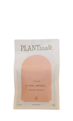 A white and beige pouch labeled "PLANTWALK" holds FIELD | Everyday Minerals Herbal Infusion—an herbal, plant-based mineral supplement. The minimalist 56g pack contains 10 sachets and features an arch-shaped graphic.