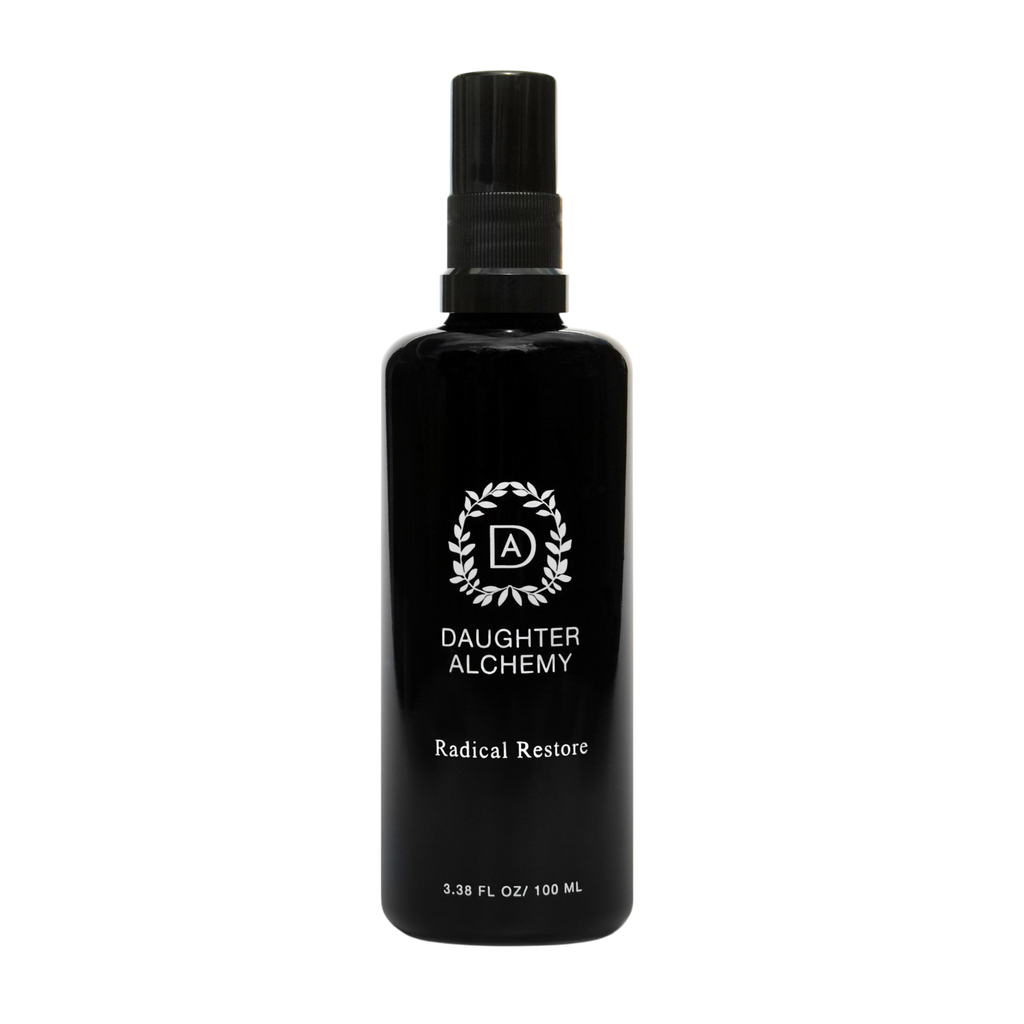 A black spray bottle labeled "Daughter Alchemy Radical Restore® Botanical Energizing Spray" with a white wreath logo, containing 3.38 fl oz (100 ml), is set against a plain white background.