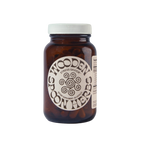 A brown glass jar with a white lid labeled "WOODEN SPOON HERBS Stress Savior" contains 90 adaptogen capsules for stress management, featuring a decorative circular design on the label.