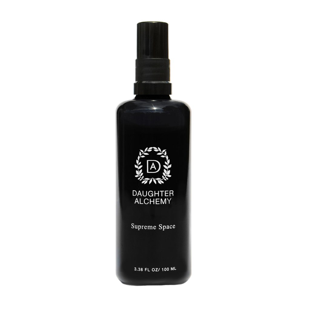 A black spray bottle labeled "Daughter Alchemy Supreme Space® Botanical Protective Spray" with a white logo and text, containing 3.38 fl oz (100 ml), stands upright on a plain white background.