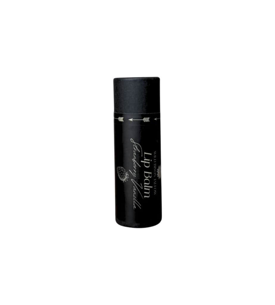 A black cylindrical tube of Wild Mamas Strawberry Vanilla Tallow Lip Balm, with minimalist white text and arrow designs, featuring nourishing bison tallow ingredients, sits on a plain white background.