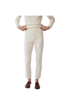A person wears Wol Hide's Easy Legging in Natural—ivory heavyweight rib cotton, high-waisted—with a matching long-sleeve top and brown slip-on shoes. The face is not shown; only the body from shoulders to feet is visible on a plain white background.