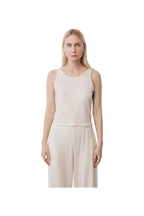 A woman with long blonde hair wears the Wol Hide Wool Tank in Natural, styled with matching wide-leg pants and standing against a plain white background.