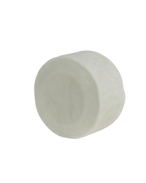 A single large white bare bar by bāeo rests on a plain white background, its smooth surface hinting at a gentle cleansing shampoo and body wash bar crafted from plant-based oils.