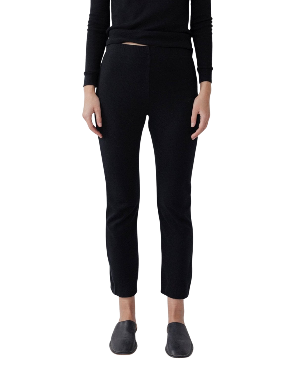 A person models Wol Hide's Easy Legging in Black—slim-fit heavyweight ribbed leggings—paired with a black long-sleeve top and black slip-on shoes, standing against a white background. The person's head is not visible.