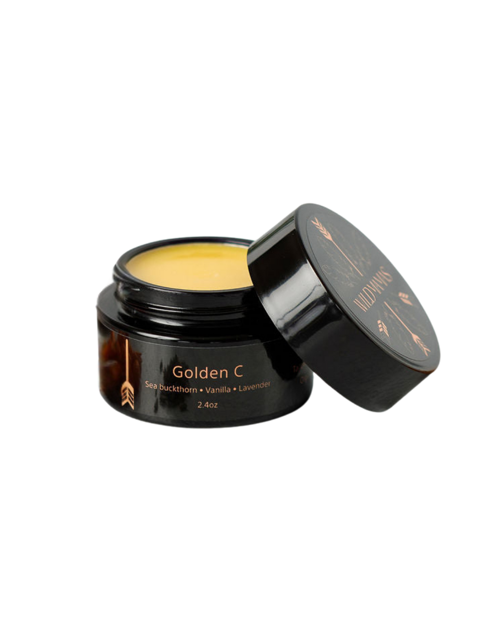 An open black jar labeled "Golden C - Wild Bison Tallow Balm" holds a yellow balm with vanilla and lavender for brightening skincare. The lid beside it features the brand name Wild Mamas.