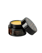 An open black jar labeled "Golden C - Wild Bison Tallow Balm" holds a yellow balm with vanilla and lavender for brightening skincare. The lid beside it features the brand name Wild Mamas.