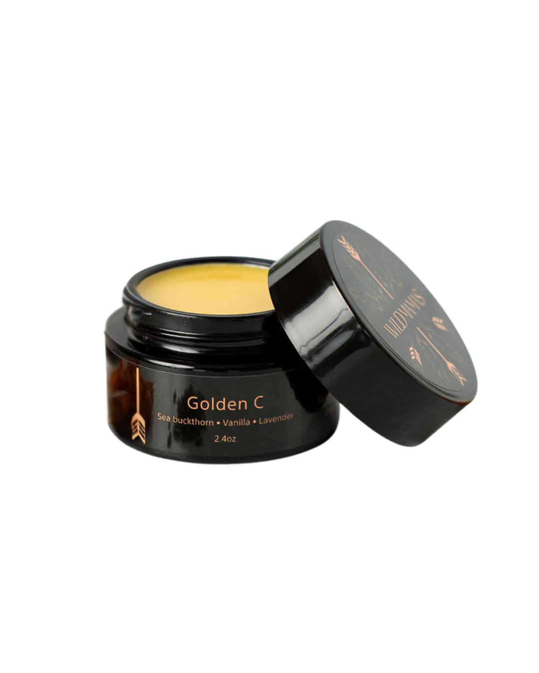 An open black jar labeled "Golden C - Wild Bison Tallow Balm" holds a yellow balm with vanilla and lavender for brightening skincare. The lid beside it features the brand name Wild Mamas.