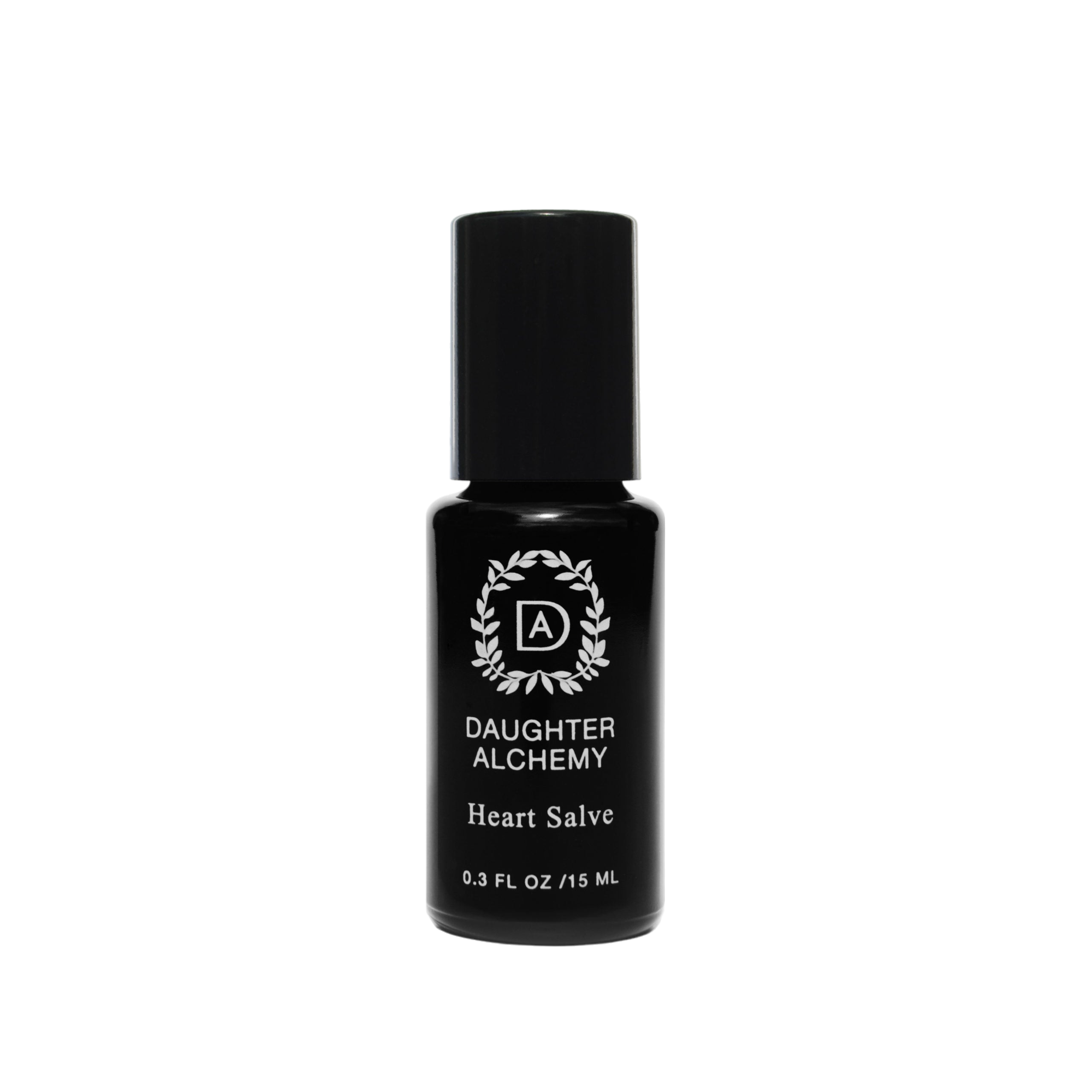 A small black bottle of Heart Salve® Botanical Nurturing Oil by Daughter Alchemy, crafted with organic ingredients, is displayed against a black background. The label features a white logo with a wreath design around the initials "DA" above the product name and indicates the bottle contains 0.3 fl oz (15 ml) of nurturing oil salve.