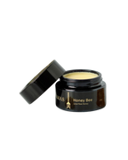 A dark brown jar labeled "Honey Bee (Raw Honey)- Wild Bison Tallow Balm" by Wild Mamas, with a slightly open black lid revealing creamy balm inside for deep hydration and skin barrier repair, set against a plain white background.