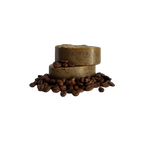 Two Wild Bison Tallow Deep Exfoliating Soap Scrub bars (Shilajit + Decaffeinated Coffee Bean) from Wild Mamas are stacked on whole coffee beans, set against a plain white background—ideal for fans of a rich coffee scrub.