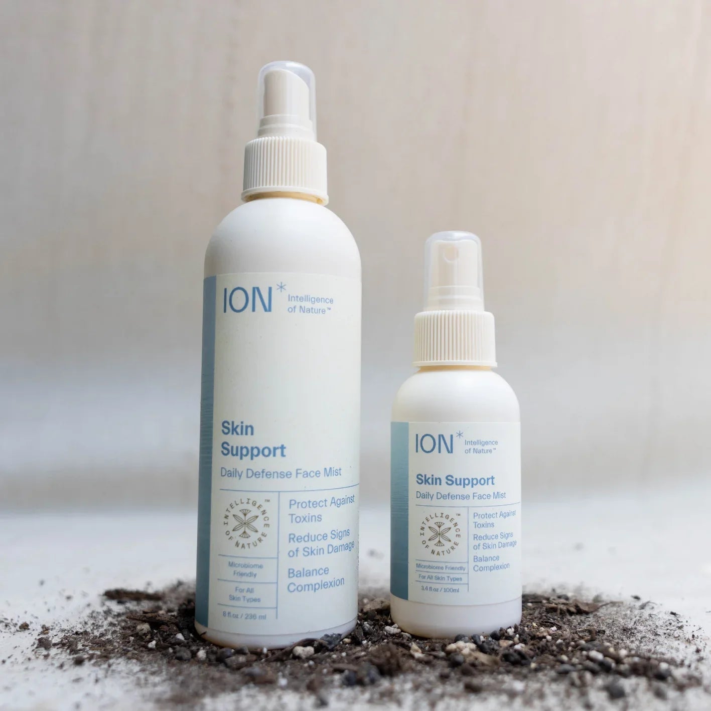 Two bottles of ION* Skin Support are placed on a white surface. The larger bottle is on the left, and the smaller bottle is on the right. The labels mention protection against toxins, reducing signs of skin damage, and balancing complexion while supporting your skin barrier.