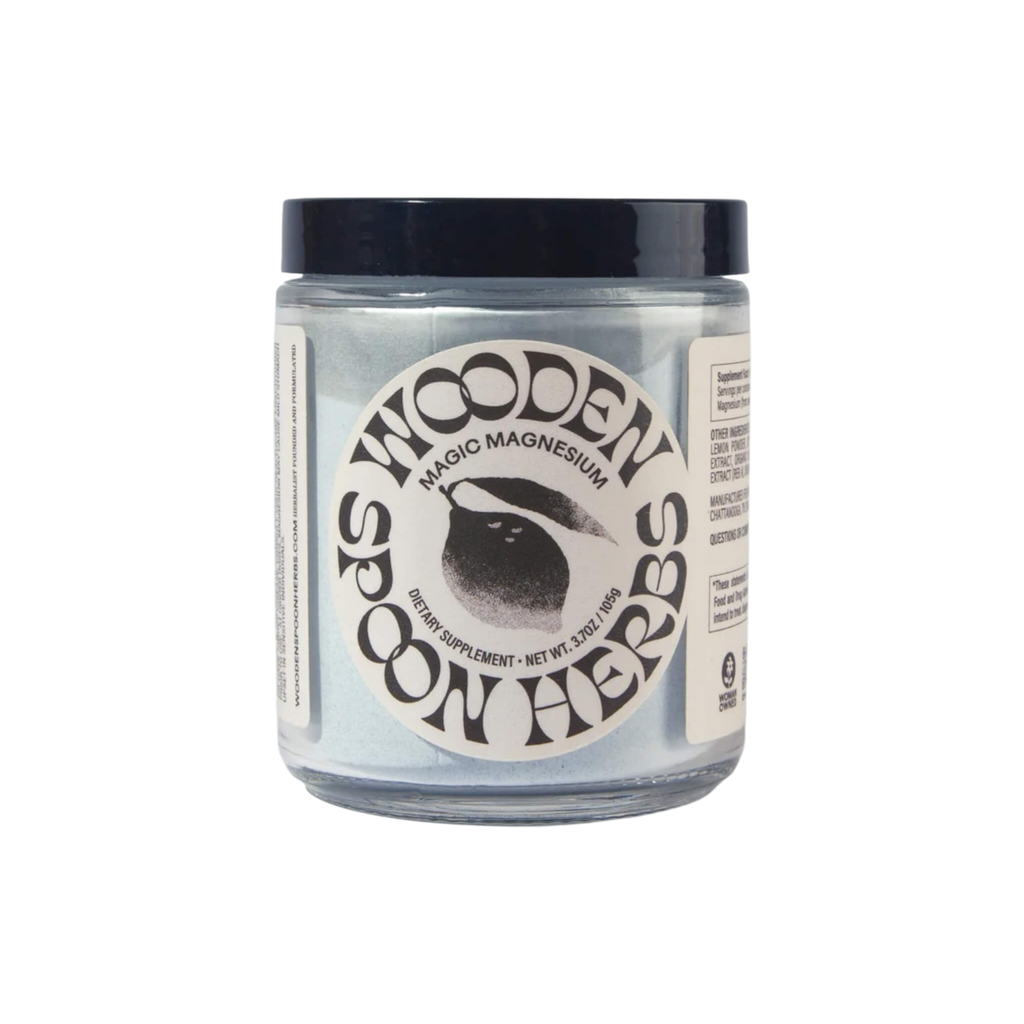 A clear jar with a dark lid labeled “WOODEN SPOON HERBS Magic Magnesium,” this powdered supplement features black text, a spoon graphic, and highlights magnesium citrate plus essential trace minerals.