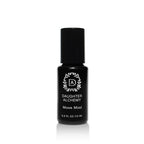 A small black bottle of Daughter Alchemy’s Moon Mind® Botanical Intuition Oil with a white logo, black cap, and text, set against a white background. This 0.3 fl oz (15 ml) oil features organic jasmine and ylang ylang essential oils.