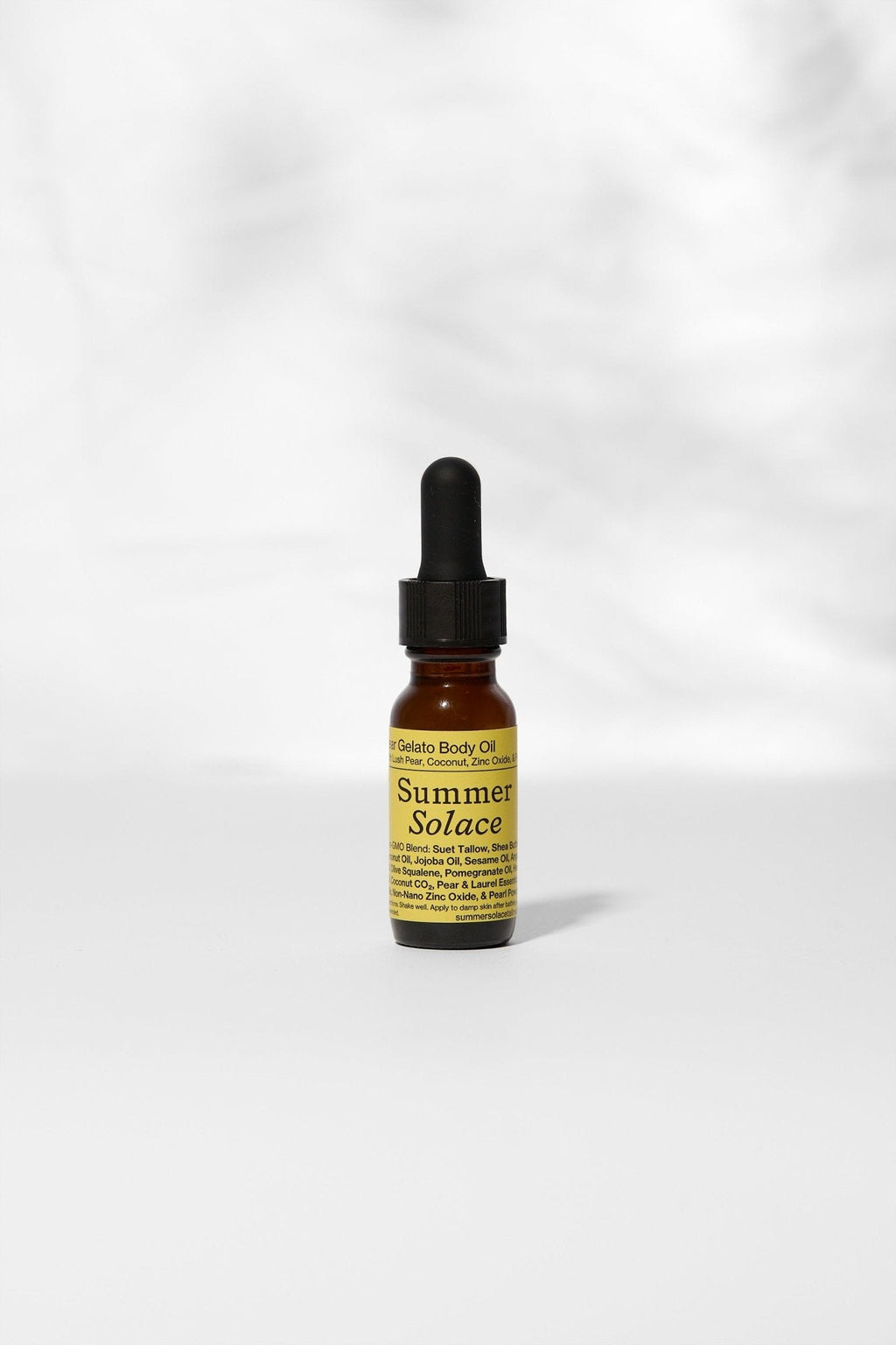 A small amber dropper bottle labeled "Summer Solace Tallow" rests on a white surface. Its label reads "Pear Gelato Body Oil – Zinc and Pearl Extract (Limited Edition)," showcasing this skin-brightening, rejuvenating body oil.