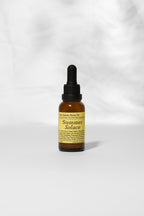 A small amber dropper bottle labeled "Pear Gelato Body Oil – Zinc and Pearl Extract (Limited Edition)" by Summer Solace Tallow, a skin-brightening oil, stands upright on a light gray surface before a soft, blurred white background.