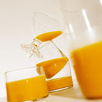 A tilted image displays three glasses from THE FULLEST's Warm Feelings 30-Day Supply, each filled with a saffron latte whose thick, yellow-orange hue exudes warmth. The creatively stacked glasses form a playful and dynamic composition against a plain white backdrop, hinting at mood enhancement with every sip.