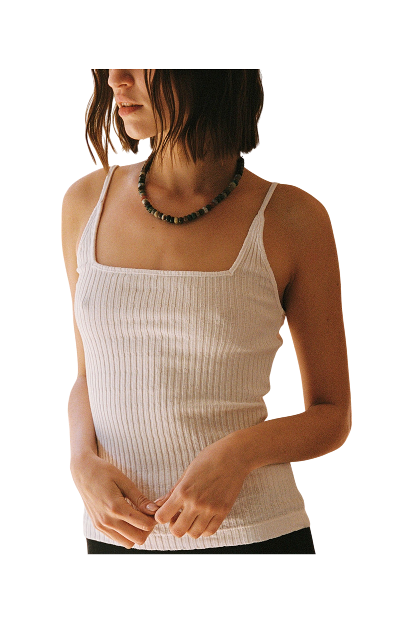 A woman with chin-length brown hair wears the LA Relaxed Pointelle Square Cami and a beaded necklace, standing against a plain background with her hands loosely clasped in front of her.